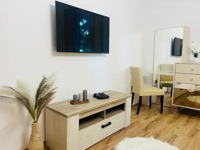 a living room with a tv on a wall at Detelina Apartment Bee Happy in Burgas in Burgas City