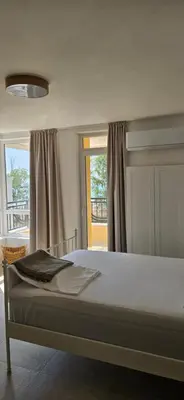 a bedroom with a large bed with a window at Cozy sea view studios in Sozopol