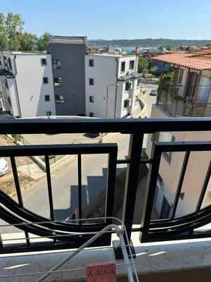 a chair on a balcony with a view of a city at Cozy sea view studios in Sozopol