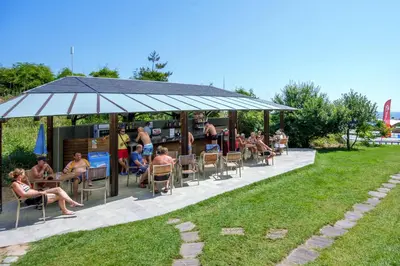 a group of people sitting in chairs under a gazebo at Jeravi Club Hotel - All Inclusive in Primorsko