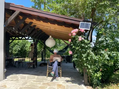 a man sitting in a chair under a pergola at Villa Suhodol