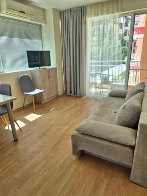 a living room with a couch and a table at Първа Линия Лазур Поморие in Pomorie