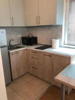 a kitchen with a sink and a microwave at Първа Линия Лазур Поморие in Pomorie