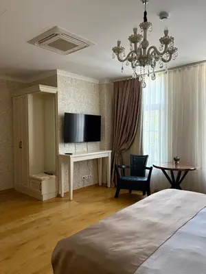 a bedroom with a bed and a tv and a chair at Hogo Fogo in Burgas City