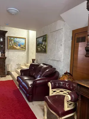 a living room with a leather couch and a chair at Hogo Fogo in Burgas City