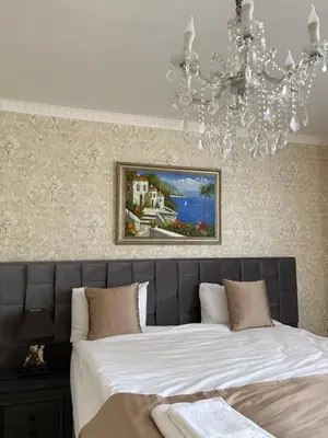 a bedroom with a large bed with a chandelier at Hogo Fogo in Burgas City
