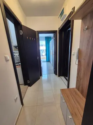 a hallway with black doors and a tile floor at Комфортен Апартамент Лазур in Pomorie