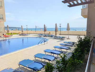 a pool with chairs and umbrellas next to a beach at Obzor Beach Resort F001 Urlaub BG in Obzor