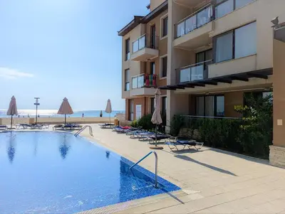 a large swimming pool next to a building with a beach at Obzor Beach Resort F001 Urlaub BG in Obzor