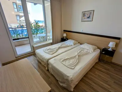 a bedroom with a bed and a large window at Obzor Beach Resort F001 Urlaub BG in Obzor