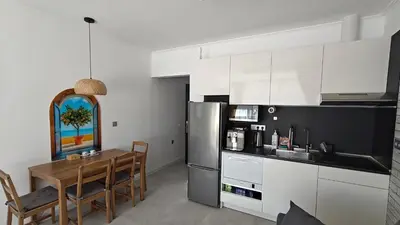 a kitchen with white cabinets and a table and a kitchen with a tableablish at Vivid Sea and City Luxury Studio 2 plus 2 in Burgas City