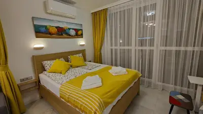 a bedroom with a bed with yellow sheets and yellow pillows at Vivid Sea and City Luxury Studio 2 plus 2 in Burgas City