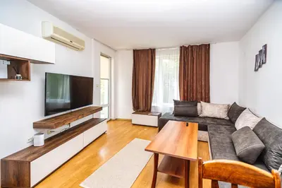 a living room with a couch and a flat screen tv at Apartment E 12 Yassen HV in Sunny Beach