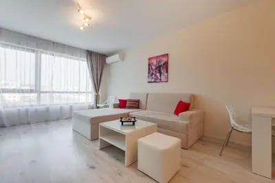 a living room with a couch and a table at АТ apartment - South Bay Beach Residence in Varna City