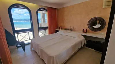 a bedroom with a bed and a view of the ocean at Beachfront Apartment Oasis VIP Club in Sunny Beach