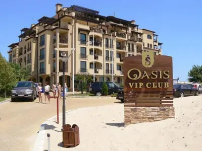 a sign in front of a building with a hotel at Beachfront Apartment Oasis VIP Club in Sunny Beach