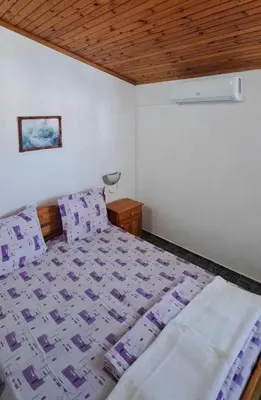 a bedroom with a bed and a wooden ceiling at Family Hotel California in Primorsko