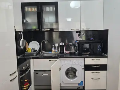 a kitchen with a washing machine and a microwave at Dolche Vita 2, Banana Tree Stay in Sveti Vlas