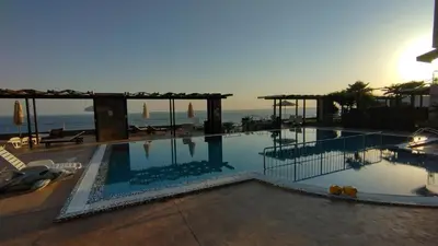 a large swimming pool with the ocean in the background at Dolche Vita 2, Banana Tree Stay in Sveti Vlas