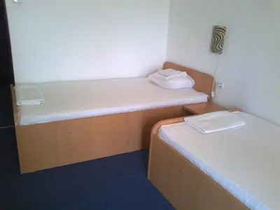a small room with two beds and two towels at Hotel Park in Burgas City