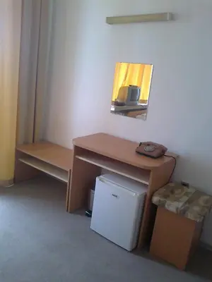 a room with a desk and a small refrigerator at Hotel Park in Burgas City