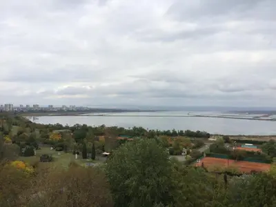 a view of a lake with a city in the background at Hotel Park in Burgas City