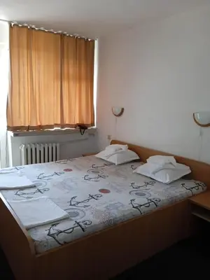 a bed with two pillows and a blanket on it at Hotel Park in Burgas City