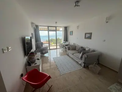 a living room with a couch and a television at Private apartment in complex Diamond in Sveti Vlas