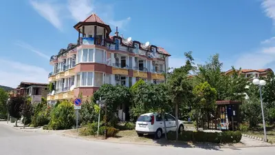 a white truck parked in front of a large building at Sunny Island Obzor in Obzor
