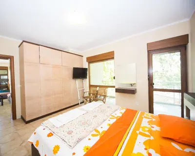 a bedroom with a large bed with an orange blanket at Lovely 2 bedrooms Flat - 1st line Central Beach Lozenets in Lozenets