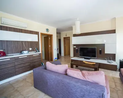 a living room with a couch and a kitchen at Lovely 2 bedrooms Flat - 1st line Central Beach Lozenets in Lozenets