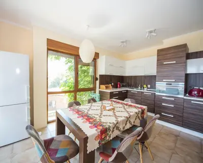 a kitchen with a table and chairs and a kitchen with a refrigerator at Lovely 2 bedrooms Flat - 1st line Central Beach Lozenets in Lozenets