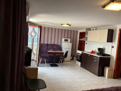 a kitchen with a table and chairs and a kitchen with a tablektop at Villa Nikoleta in Sveti Vlas