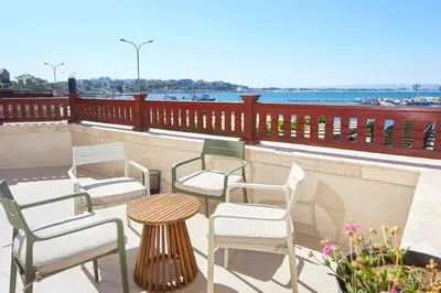 a group of chairs and a table on a balcony at Семеен хотел НОА in Nesebar