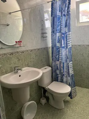 a bathroom with a toilet and a sink and a mirror at Хотел Грация in Lozenets