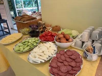 a table with different types of food on plates at Хотел Грация in Lozenets