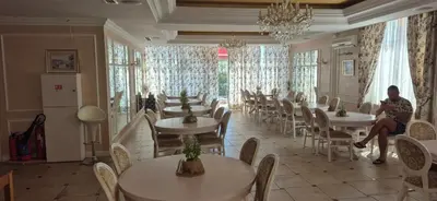a restaurant with tables and chairs and a person sitting on a chair at Apartment Sofia Macon Residence Sveti Vlas in Sveti Vlas