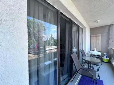 a balcony with a table and chairs and a window at морско бижу in Byala