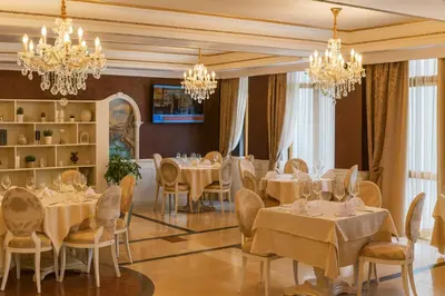 a restaurant with white tables and chairs and chandeliers at Romantic Studio Florence in Sveti Vlas
