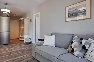 a living room with a couch and a refrigerator at Green Corner Apartment in the Center - 2BD in Burgas City