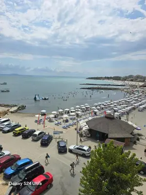 a group of cars parked on a beach at Апартамент Хелиос Поморие in Pomorie