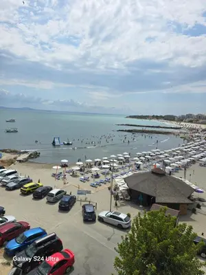 a group of cars parked at a beach with people at Апартамент Хелиос Поморие in Pomorie