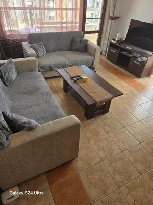 a living room with two couches and a coffee table at Апартамент Хелиос Поморие in Pomorie