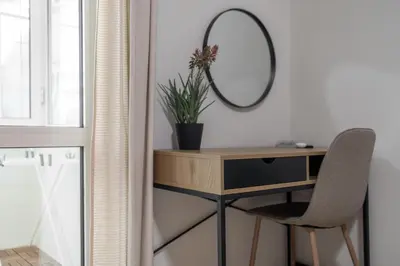 a desk with a mirror and a chair in a room at City Center Gem Varna - 5 Guests in Varna City
