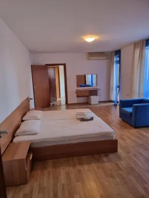a large bedroom with a large bed and a blue couch at Трёхкомнатная квартира in Sveti Vlas