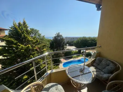 a balcony with a table and chairs and a pool at Sunny Seasons top view apartment SEA&POOL in Byala
