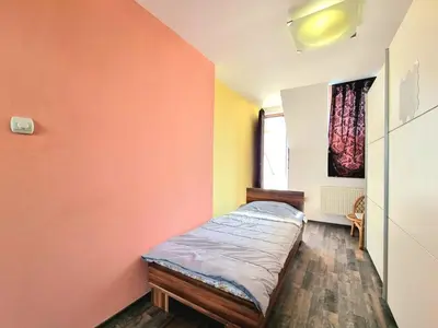 a bedroom with an orange wall with a bed in it at Sea Star Studio-to the Sea Garden in Burgas City