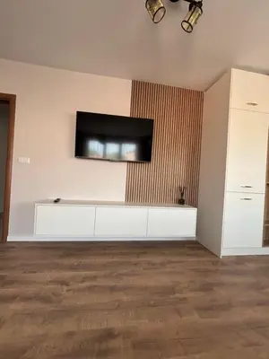 a living room with a flat screen tv on the wall at Дизайнерски апартамент in Burgas City