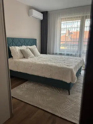 a bedroom with a bed and a window at Дизайнерски апартамент in Burgas City