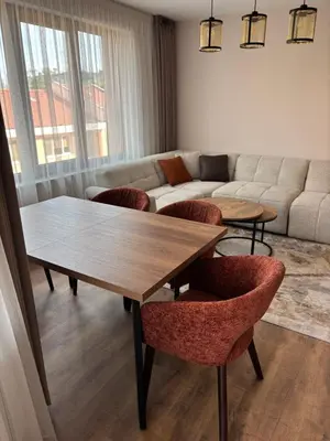 a living room with a table and chairs and a couch at Дизайнерски апартамент in Burgas City